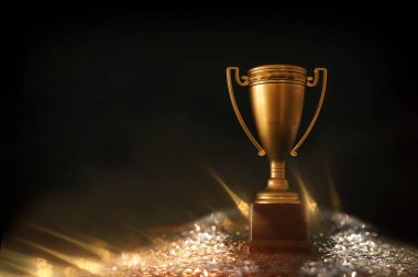 düşük anahtar görüntü Trophy üzerinde ahşap masa ve soyut parlak ışıklar ile koyu arka plan