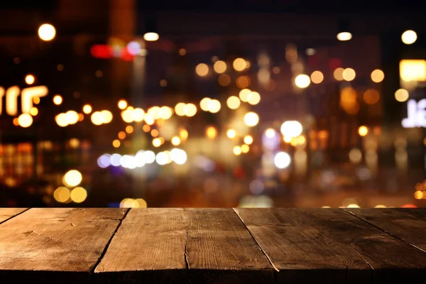 Φόντο εικόνα του ξύλινου τραπεζιού μπροστά από το δρόμο αφηρημένη θολή φώτα προβολή — Φωτογραφία Αρχείου