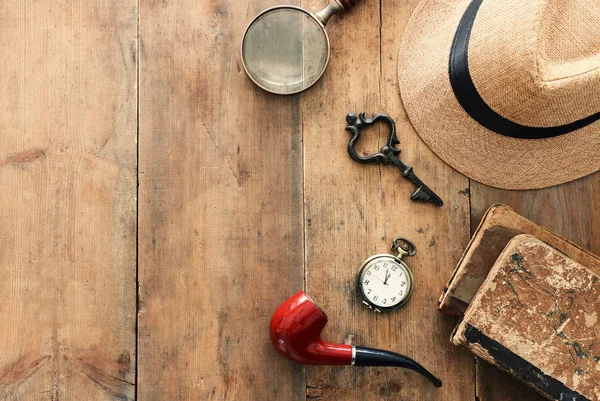 Imagem conceitual de investigação ou detetive particular. Chapéu Fedora, lupa e itens vintage sobre mesa de madeira — Fotografia de Stock