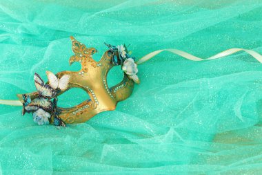 Zarif ve narin altın rengi Venedik maskesinin fotoğrafı.