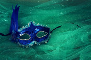 Zarif ve narin mavi Venedik maskesinin fotoğrafı nane şifon arka planda.