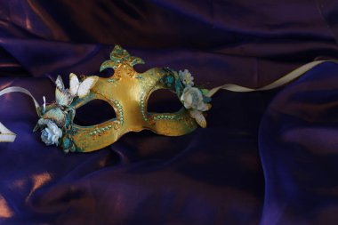Mor ipek arka planda zarif ve narin Venedik maskesinin fotoğrafı