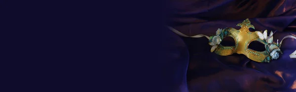 紫の絹の背景にエレガントで繊細な金のベネチアンマスクの写真 — ストック写真