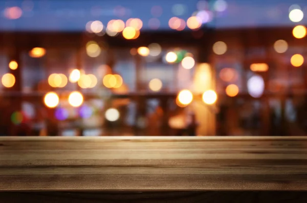 Tło Obraz drewnianego stołu przed abstrakcyjnymi rozmytymi światłami restauracji — Zdjęcie stockowe