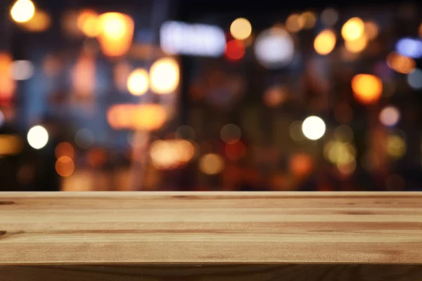 추상적으로 흐릿 한 레스토랑 불빛 앞에 놓인 나무 탁자의 배경 이미지 — 스톡 사진