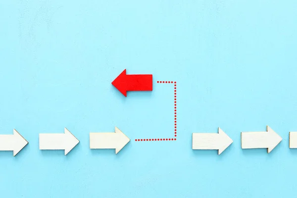 Onderwerp afbeelding van rode pijl naar de tegenovergestelde richting van andere pijlen in groep. Individualiteit en ambitie metafoor — Stockfoto