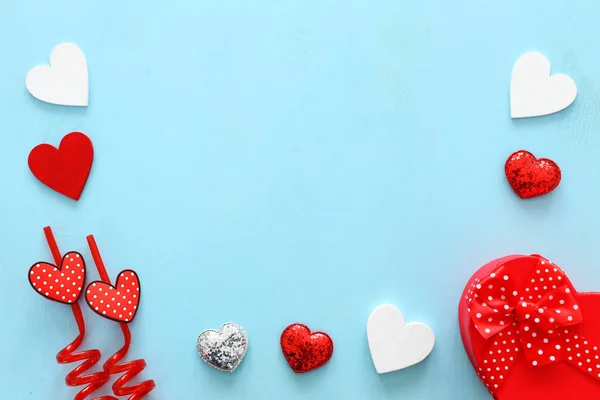 Concepto de San Valentín. corazones y caja de regalo sobre fondo azul madera. Composición laica plana — Foto de Stock