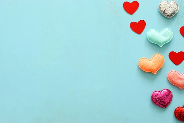 Conceito do dia dos namorados. vermelho brilho corações sobre fundo azul de madeira. Composição plana — Fotografia de Stock