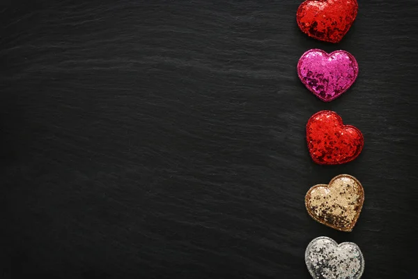 Concept de Saint Valentin. coeurs rouges paillettes sur fond noir. Composition de la couche plane — Photo