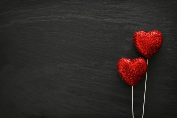 Concept de Saint Valentin. coeurs rouges paillettes sur fond noir. Composition de la couche plane — Photo