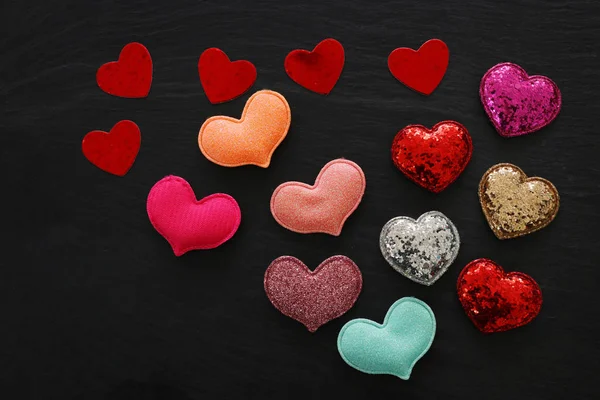Concepto de San Valentín. corazones de purpurina roja sobre fondo negro. Composición laica plana —  Fotos de Stock