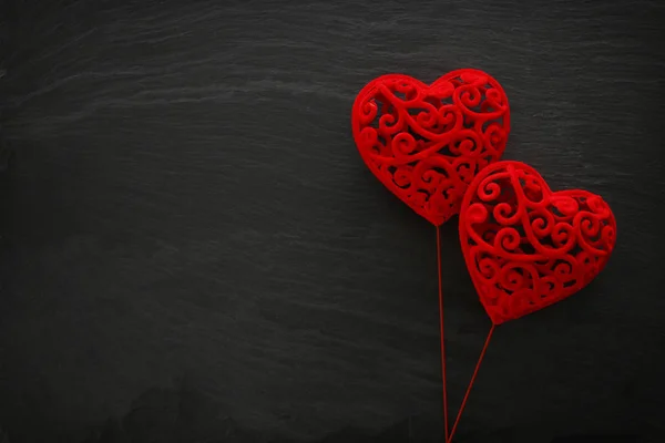 Concetto di San Valentino. cuori di velluto rosso su sfondo nero. Composizione laica piatta — Foto Stock