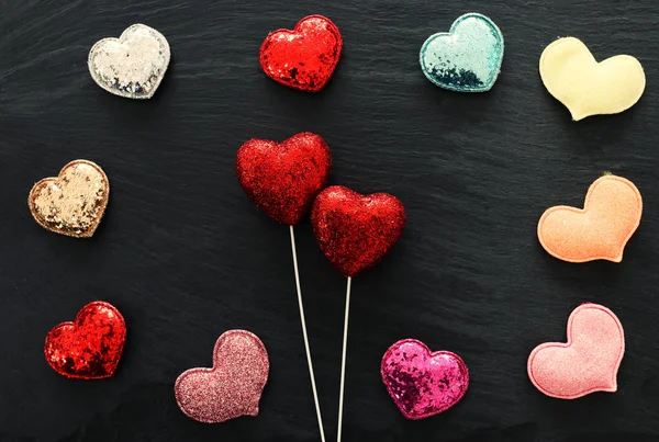 Valentijnsdag concept. rode glitter hartjes over zwarte achtergrond. Samenstelling van de vlakke vloer — Stockfoto