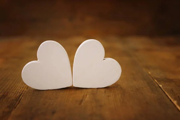 Η ιδέα του Αγίου Βαλεντίνου. λευκές καρδιές πάνω από ξύλινο φόντο. Επίπεδη σύνθεση — Φωτογραφία Αρχείου