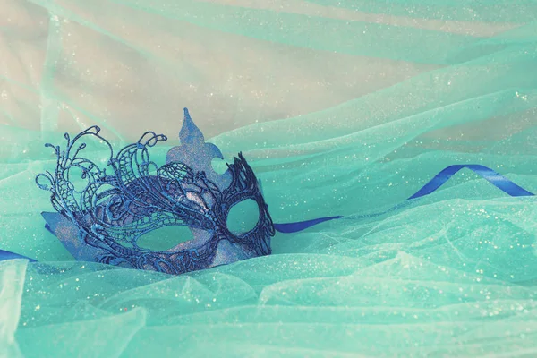 Zarif ve narin mavi Venedik maskesinin fotoğrafı nane şifon arka planda.