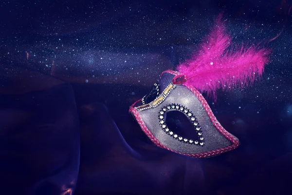 Photo of elegant and delicate pink Venetian mask over purple silk background — 스톡 사진