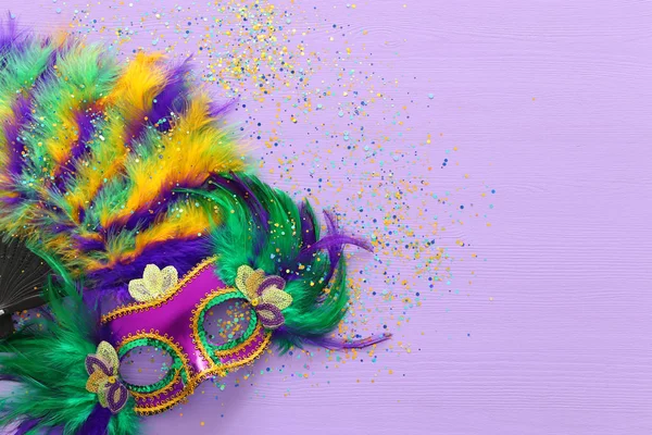 Imagen festiva de la mascarada de mardi gras, máscara veneciana y abanico sobre fondo púrpura. vista desde arriba — Foto de Stock