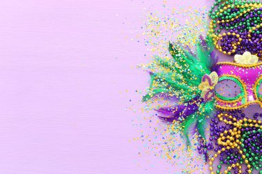 Mardi Gras 'nın bayram görüntüsü mor arka planda Venedik maskesini maskeliyor. Yukarıdan görünüm
