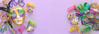 Purim kutlama kavram (Yahudi karnaval tatil) mor ahşap arka plan üzerinde. Üstten görünüm, düz lay