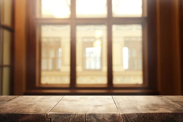 Obrázek dřevěný stůl před abstraktní rozmazané okna světlé pozadí — Stock fotografie