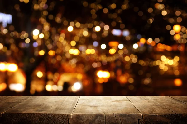 Background Image of wooden table in front of street view in front of abstract blurred lights — 스톡 사진