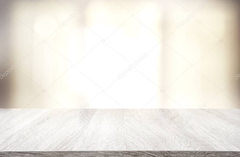 image of wooden table in front of abstract blurred window light background