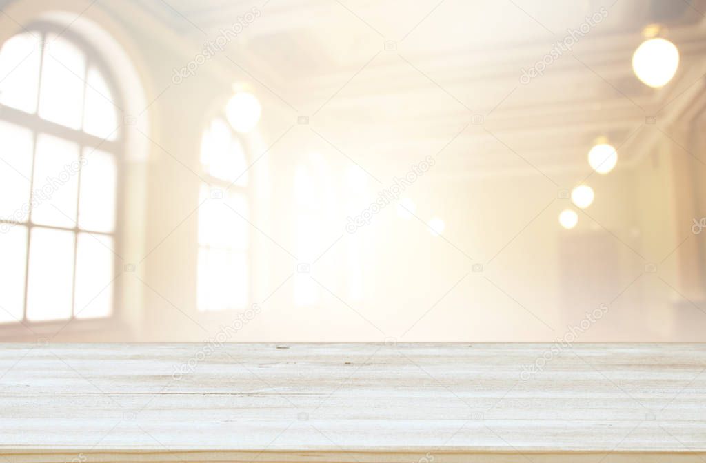 image of wooden table in front of abstract blurred window light background