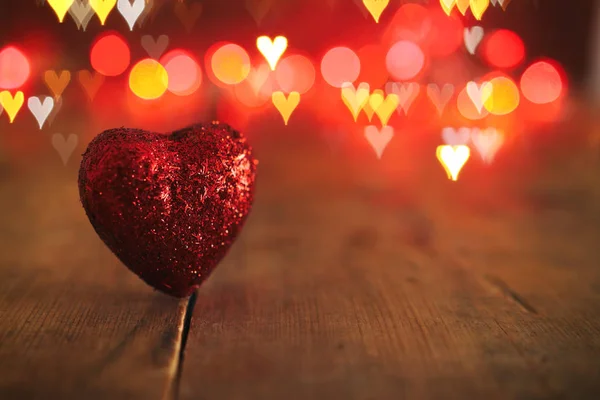 Concetto di San Valentino. un cuore su sfondo di legno e luci glitter — Foto Stock