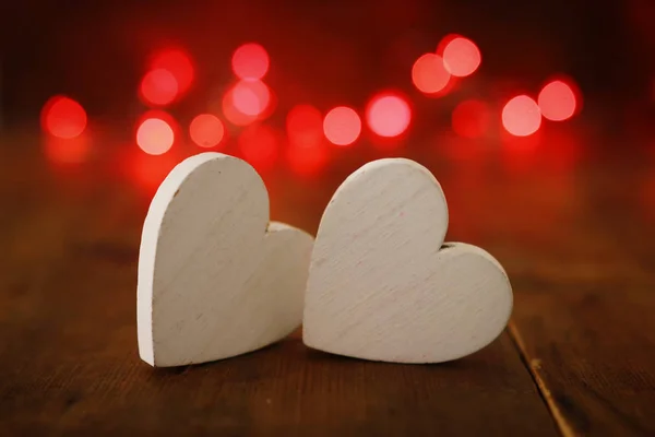 Valentijnsdag concept. twee harten over houten achtergrond en glitterlichten — Stockfoto