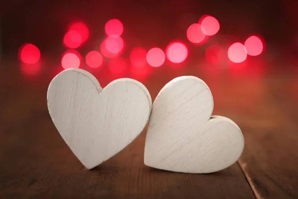 Concepto de San Valentín. dos corazones sobre fondo de madera y luces de brillo — Foto de Stock