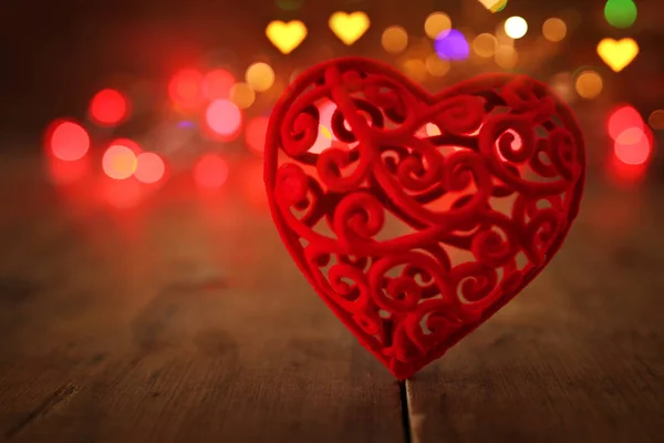 Concepto de San Valentín. un corazón sobre fondo de madera y luces de brillo —  Fotos de Stock
