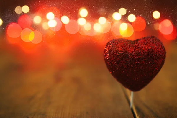 Concepto de San Valentín. un corazón sobre fondo de madera y luces de brillo — Foto de Stock