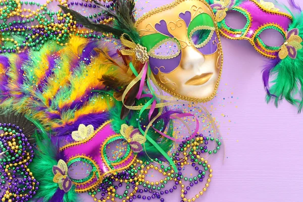Imagen festiva de la mascarada de mardi gras, máscara veneciana y abanico sobre fondo púrpura. vista desde arriba —  Fotos de Stock