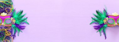 Mardi Gras 'nın bayram görüntüsü mor arka planda Venedik maskesini maskeliyor. Yukarıdan görünüm