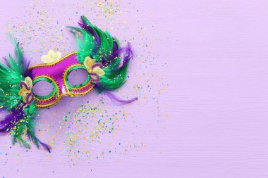 Mardi Gras 'nın bayram görüntüsü mor arka planda Venedik maskesini maskeliyor. Yukarıdan görünüm