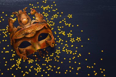 Koyu ahşap zemin üzerinde zarif ve narin Yunan veya Roma paslı Venedik maskesi fotoğrafı