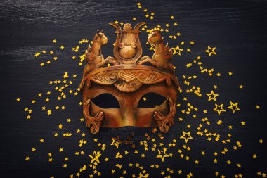 Koyu ahşap zemin üzerinde zarif ve narin Yunan veya Roma paslı Venedik maskesi fotoğrafı