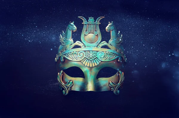 Zdjęcie eleganckiego i delikatnego greckiego lub rzymskiego złota z niebieską wenecką maską na ciemnym drewnianym tle — Zdjęcie stockowe