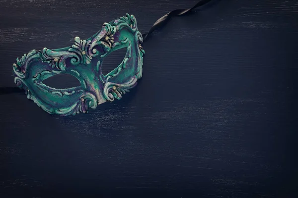 濃い木製の背景にエレガントで繊細な青のベネチアンマスクの写真 — ストック写真