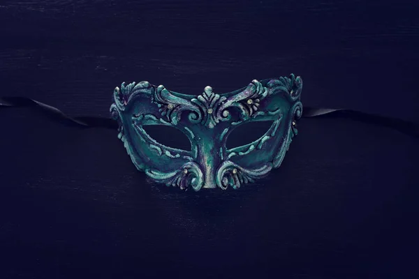 Фото витонченої і делікатної синьої венеціанської маски над темним дерев'яним фоном. — стокове фото