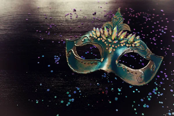 Photo of elegant and delicate blue Venetian mask over dark wooden background — 스톡 사진