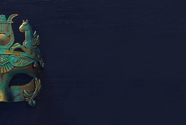 Фото элегантного и нежного греческого или римского золота с синей венецианской маской на темном деревянном фоне — стоковое фото
