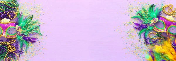 Праздничное изображение маскарада Марди Гра, венецианской маски и веера на фиолетовом фоне. вид сверху — стоковое фото