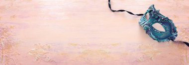 Pastel ahşap arka planda zarif ve narin mavi Venedik maskesi.