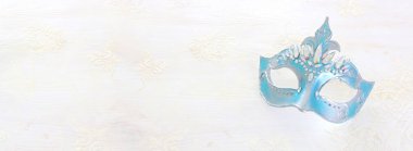 Beyaz ahşap zemin üzerinde zarif ve narin mavi Venedik maskesi fotoğrafı