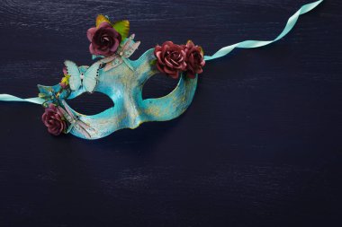 Zarif ve narin mavi Venedik maskesinin koyu ahşap arka planda fotoğrafı