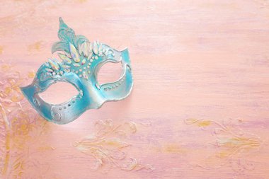 Pastel ahşap arka planda zarif ve narin mavi Venedik maskesi.
