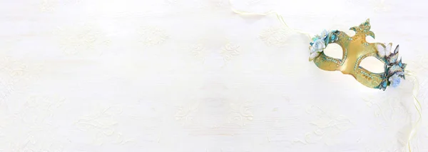 Foto de elegante y delicada máscara veneciana de oro sobre fondo de madera blanca —  Fotos de Stock