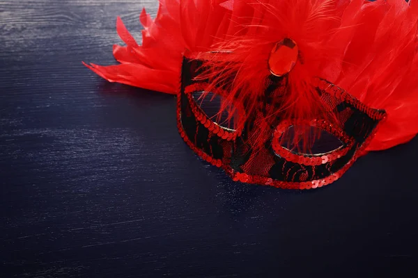 Foto von eleganten roten venezianischen Maske über dunklem Holzhintergrund — Stockfoto