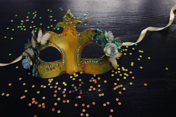 Photo of elegant and delicate gold Venetian mask over dark wooden background — Stock Photo, Image